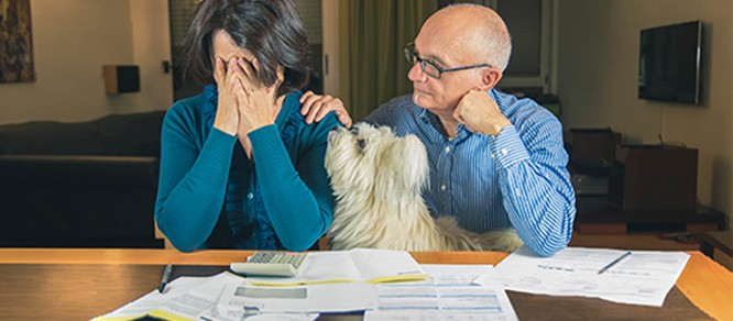couple sad over bills with dog